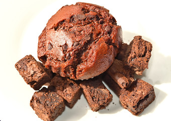 Delicious Double Chocolate Muffin with Choco Chips isolated closeup on a white plate.