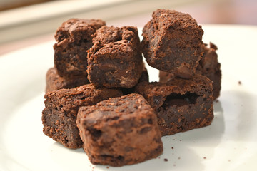 Delicious Chocolate Brownies group closeup on a white plate with blurred background.
