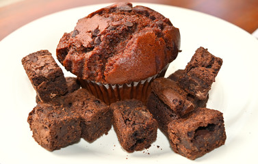 Delicious Double Chocolate Muffin with Chocolate Brownies closeup on a white plate.