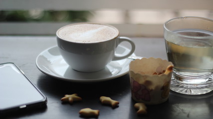 cup of coffee and cookies on wooden table
