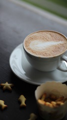 cup of coffee with cream on wooden background