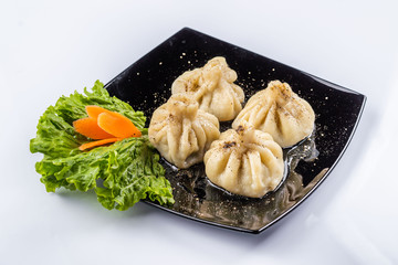 Georgian dumplings Khinkali with meat and red papper, on brown plate