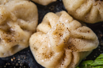 Georgian dumplings Khinkali with meat and red papper, on brown plate