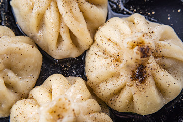 Georgian dumplings Khinkali with meat and red papper, on brown plate