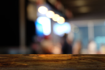 Empty dark wooden table in front of abstract blurred bokeh background of restaurant . can be used for display or montage your products.Mock up for space.