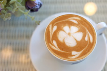 frangipani plumeria fragrant flower of latte art in hot coffee drink put on table in cafe restaurant