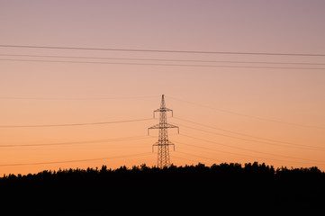 Fototapeta premium High voltage tower with silhouette sky sunset background