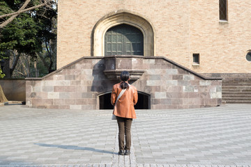 Fototapeta na wymiar Waseda, Tokyo, Japan, 03/23/2019 , Waseda University Campus. Woman standing in front of Okuma auditorum.