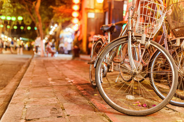 Naklejka na ściany i meble Scenic evening view of vintage style bicycles parked on sidewalk
