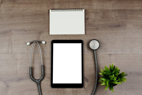 Digital Tablet With Blank Screen And Stethoscope On Wooden Desk