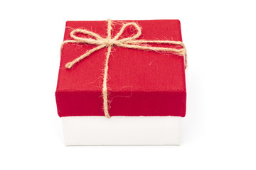 Red gift box tied with a rope tied into a bow isolated on a white background