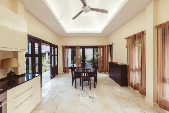 Big dining room interior. Open space, big doors to tropical garden, fan on  ceiling