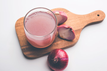 Medicinal Onion juice/syrup in a glass with raw onions. selective focus