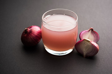 Medicinal Onion juice/syrup in a glass with raw onions. selective focus