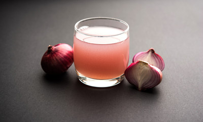 Medicinal Onion juice/syrup in a glass with raw onions. selective focus