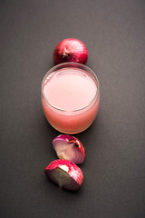 Medicinal Onion juice/syrup in a glass with raw onions. selective focus