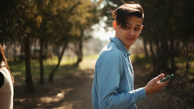  two young hurry strangers with smartphones in hands suddenly collided in the park