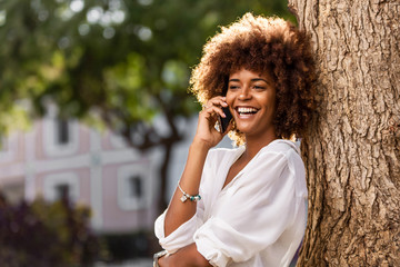 Outdoor portrait of a Young black African American young woman speaking on mobile phone