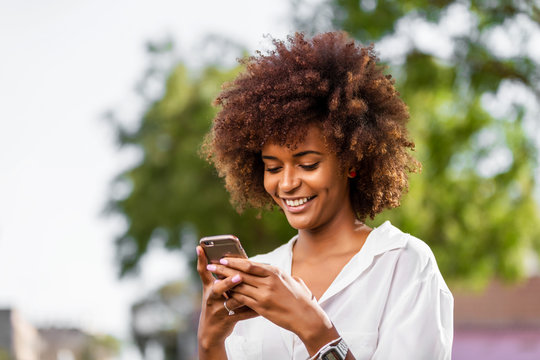 Outdoor portrait of a Young black African American young woman speaking on mobile phone