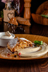 Concept of Austrian cuisine. Apple pie puff pastry. Strudel with apples and cinnamon. Serving dishes in a restaurant with a scoop of ice cream and sugar powder. copy space