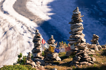Glacier in the alps with buddhistic flags and stone tower