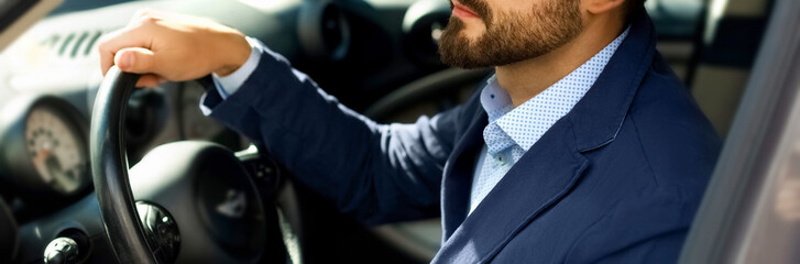 Handsome smiling bearded man in car