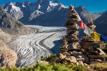 Glacier in the alps with buddhistic flags and stone tower