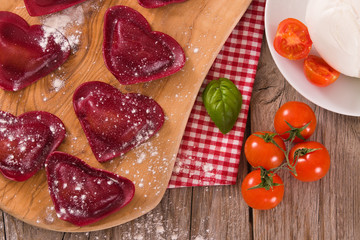Red heart ravioli with tomato, mozzarella and basil.