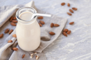 Bottle of healthy almond milk on table