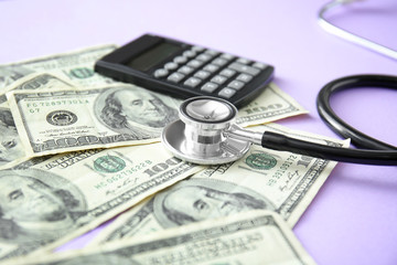 Stethoscope, calculator and dollar banknotes on color background. Concept of payment for medical...