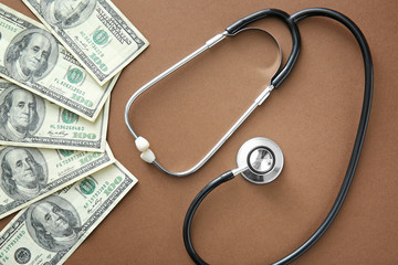 Stethoscope and dollar banknotes on color background. Concept of payment for medical service