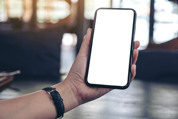 Mockup image of a woman's hand holding black mobile phone with blank desktop screen