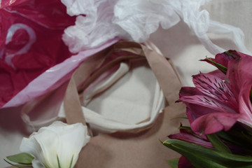 Fototapeta premium paper bag with flowers and plastic bag polluting the environment