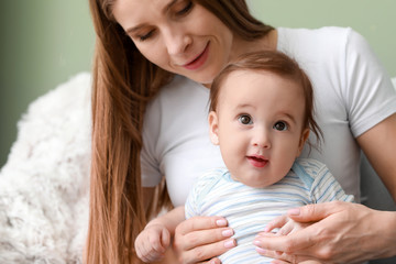 Happy mother with adorable baby boy at home