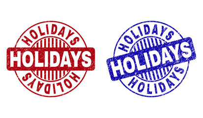 Grunge HOLIDAYS round stamp seals isolated on a white background. Round seals with grunge texture in red and blue colors. Vector rubber overlay of HOLIDAYS text inside circle form with stripes.