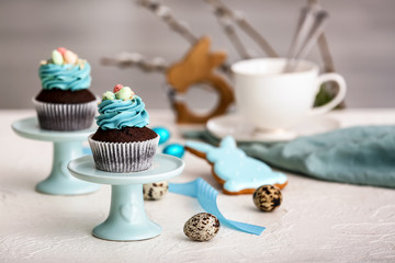 Tasty Easter cupcakes on table