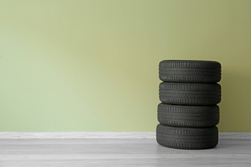 Fototapeta na wymiar Car tires near color wall
