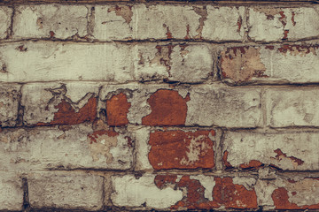 Texture of dilapidated brick wall close up. Dirty shabby brick wall in white peeling paint. White brick wall texture background. Grunge texture. Old red brick wall background. Old dirty wall texture. 