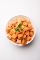 Cantaloupe / muskmelon / kharbuja cut into pieces, served in a bowl. selective focus