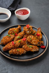 Chicken nuggets with sauce and pepper on a dark background. Copy space.
