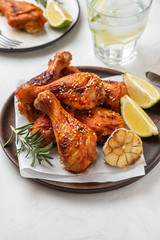 Chicken legs with sauce, rosemary and lime on a white background. Copy space.