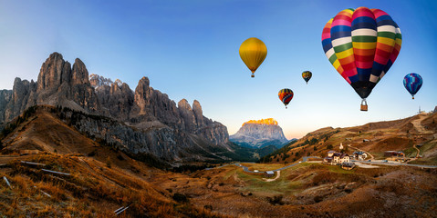 Beautiful panoramic nature landscape of countryside mountains with colorful high hot air balloons festival in summer sky. Vacation travel panorama background.
