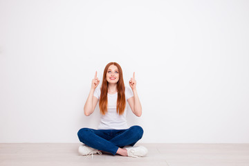Fototapeta premium Full length body size photo beautiful she her lady sit floor legs crossed fingers raised up indicate look empty space advise buy buyer wear casual t-shirt jeans denim clothes isolated white background