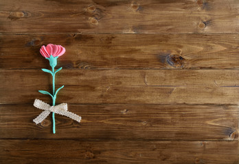 Hand made used felt, pink carnation on wooden background.Mothers Day(24-1)