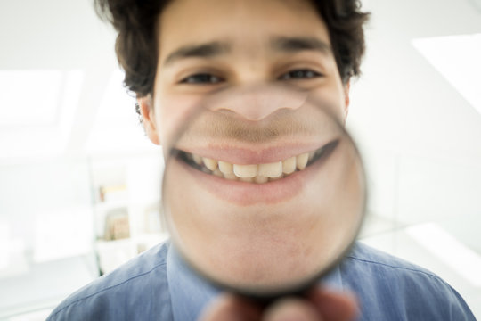 Cute boy with magnifier smiling