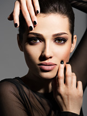 Fototapeta na wymiar Face of a beautiful girl with fashion makeup and black nails
