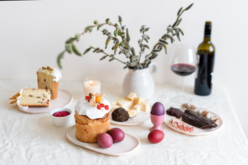 Serving Easter table with tasty dishes and glass of wine