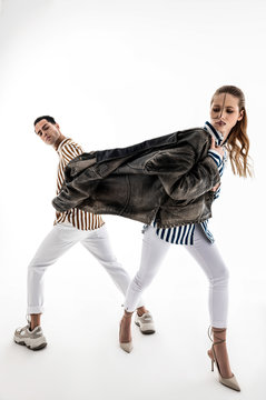 Male and female models wearing white trousers posing in one jacket