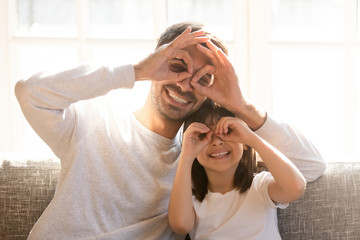 Father and little kid daughter plying tricks at home