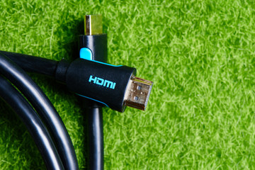 Black HDMI cable adapter connector on the background of green lawn